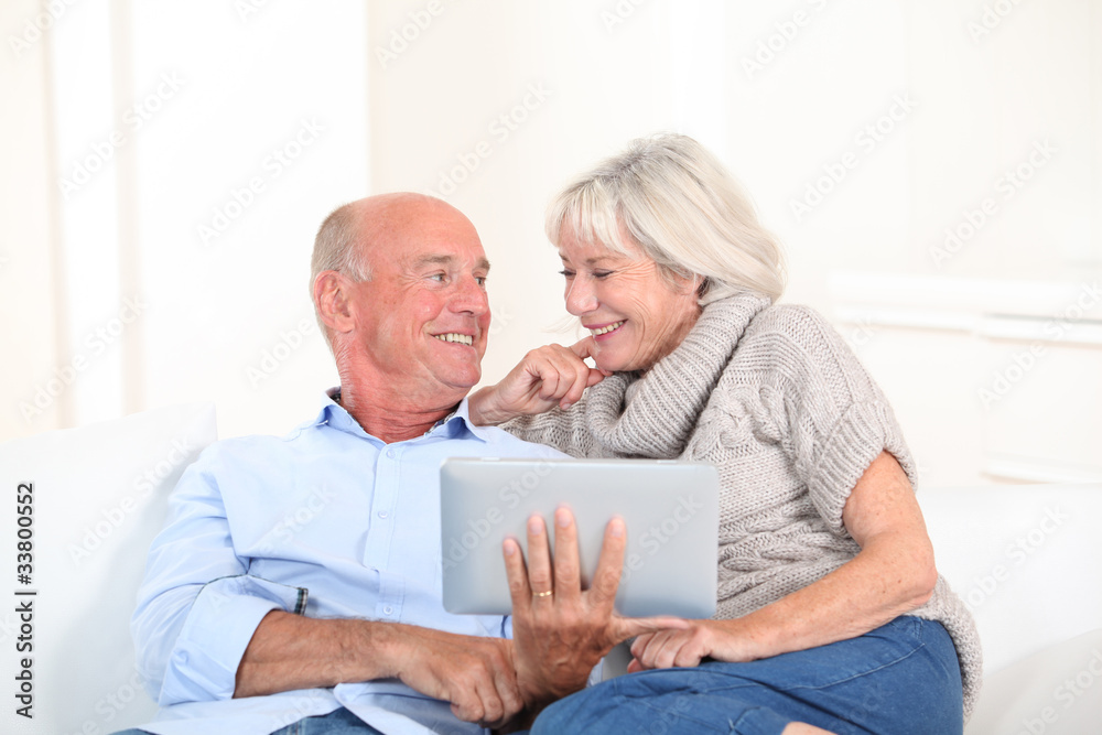 Senior couple using electronic tablet at home Senior couple using electronic tablet at home