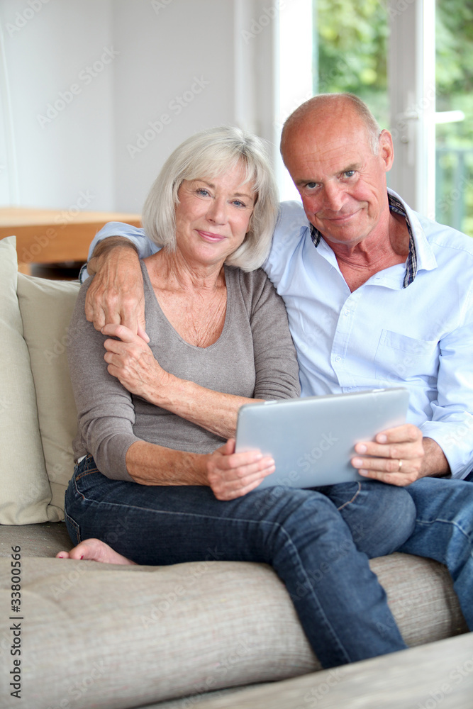 Senior couple using electronic tablet at home Senior couple using electronic tablet at home