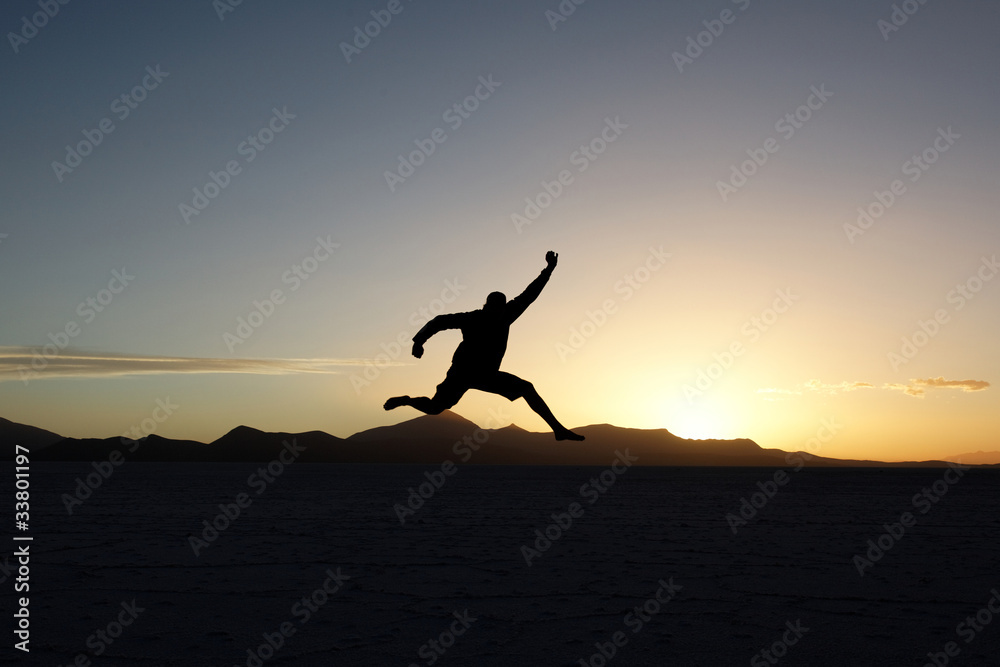 Silhouette of jumping man at sunset
