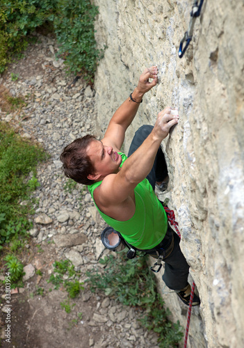 Rock climber struggling to reach next handhold