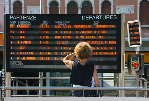 Women reads train departure infornation in Venice, Italy