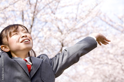 桜の前でのびをする女子高生 photo