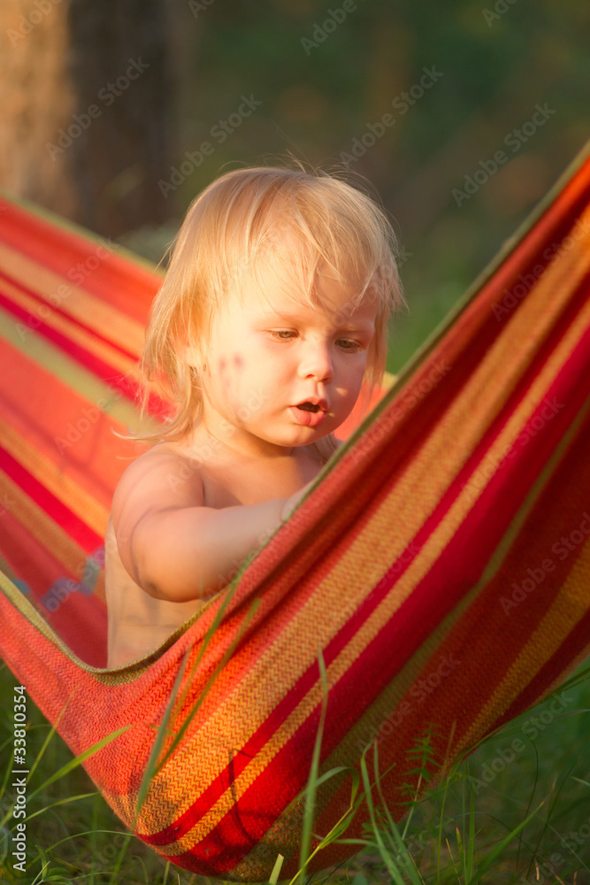 Adorable baby girl sit and look around relaxing in hammock Adorable baby girl sit and look around relaxing in hammock