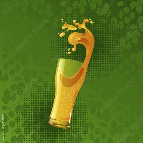 Frosty glass of light beer with splash on green background