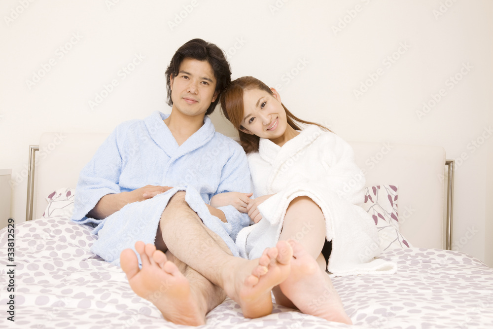 ベッドの上で寄り添う男女 ベッドの上で寄り添う男女