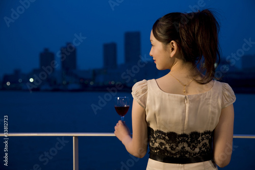 Plakat テラスでワインを飲む女性