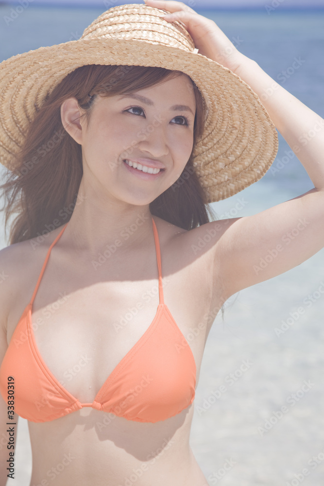 海辺で麦わら帽子を被る水着女性 Stock Photo Adobe Stock