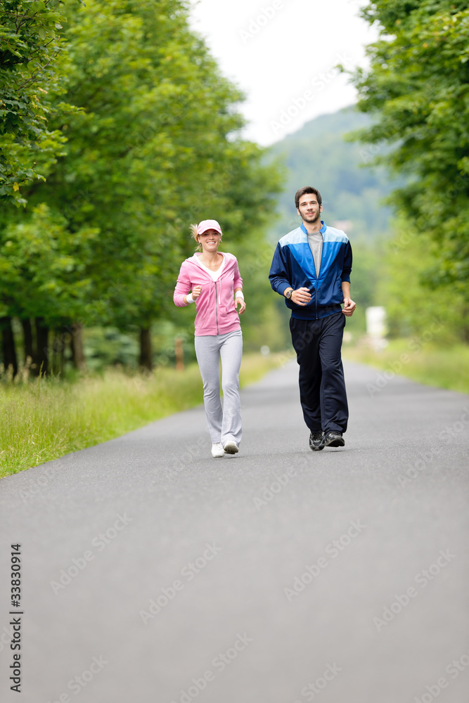 Jogging sportive young couple running park road Jogging sportive young couple running park road