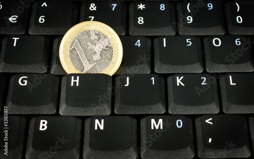 euro coin on laptop keyboard