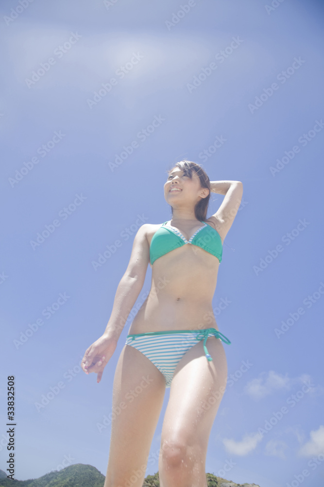 青空を見上げる水着女性