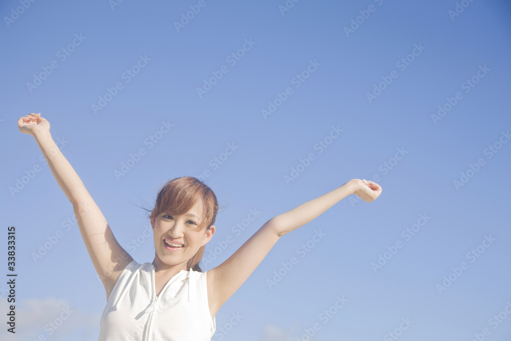 青空の下で両手を広げる女性 青空の下で両手を広げる女性