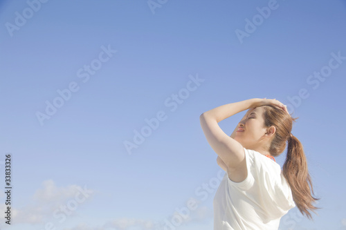 髪をかきあげながら空を見上げる女性