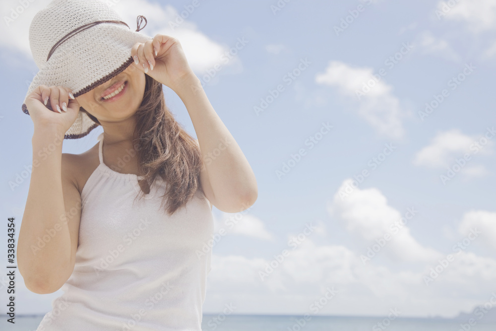 Fototapeta premium 帽子の鍔で目を隠す女性