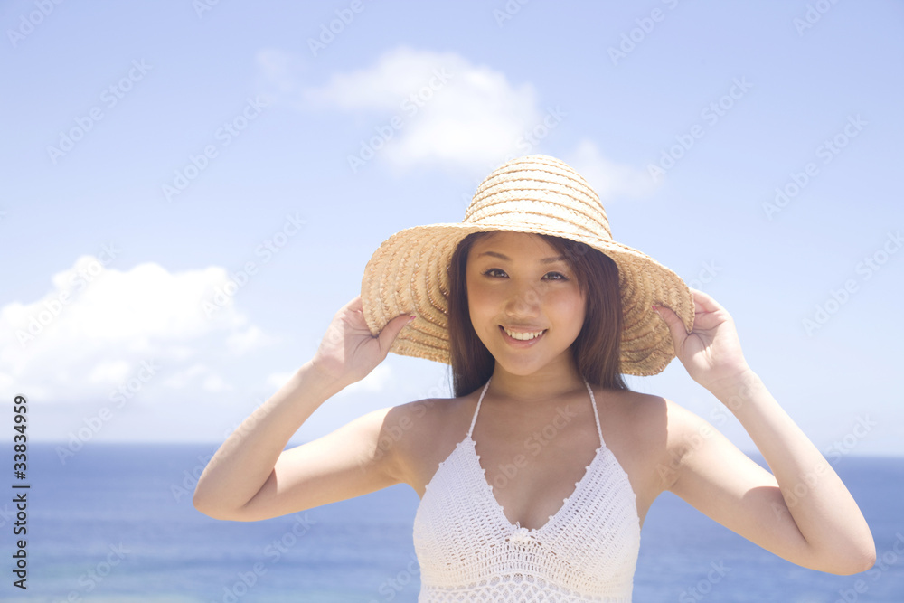 麦わら帽子のつばを持って微笑む女性 麦わら帽子のつばを持って微笑む女性