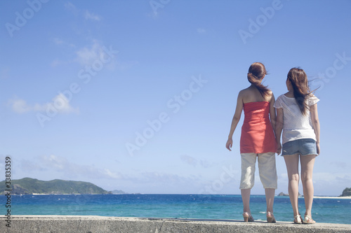 海辺に立つ女性2人の後ろ姿 © paylessimages