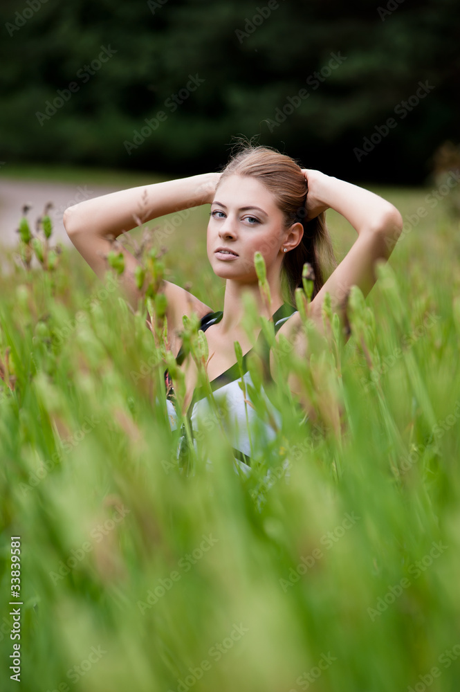 Beautiful young woman among the grass in a field Beautiful young woman among the grass in a field