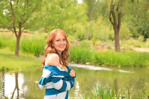 Pretty girl smiling by a pond