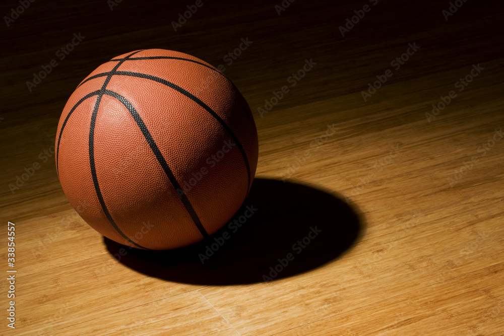Basket ball sitting on wood floor Basket ball sitting on wood floor