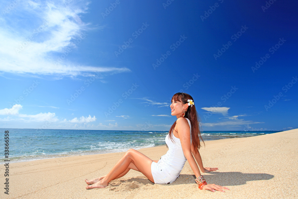 砂浜に座り海を眺める女性 砂浜に座り海を眺める女性
