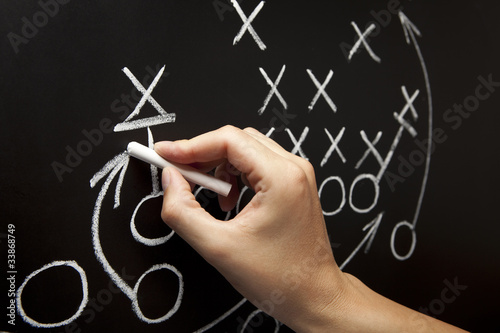 Coach Drawing American Football Game Strategy On Blackboard