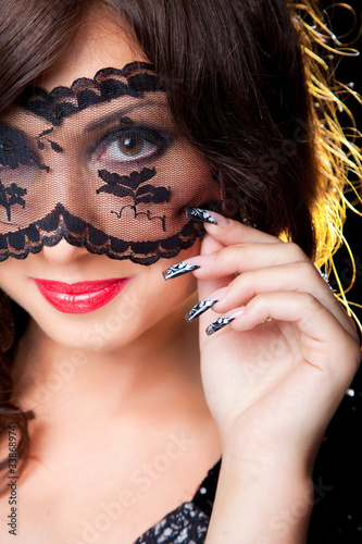 Attractive brunette girl with lacy mask on her eyes