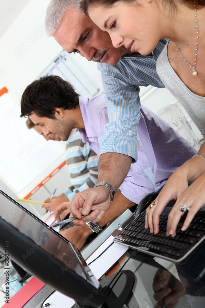 students and teacher working with laptop in college students and teacher working with laptop in college