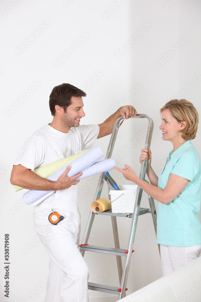 man and woman with wallpaper rolls man and woman with wallpaper rolls