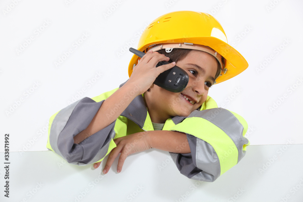 a little boy dressed in road man with a cell phone a little boy dressed in road man with a cell phone