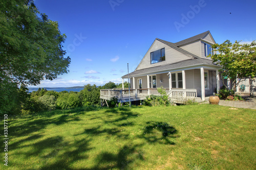 Grey house with white trim and water view.