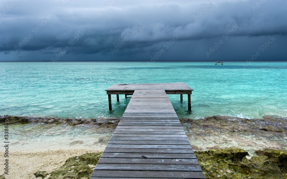 Obraz premium wooden bridge on beach extended into the sea