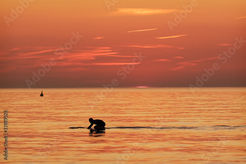 Surfer in the water at sundown