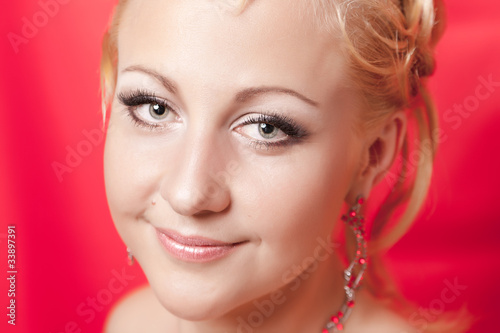 Portrait of the girl with a smile on a red background