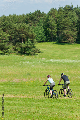 Sport mountain couple biking downhill sunny meadows