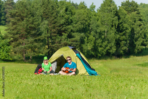 Young camping couple cooking meal play guitar