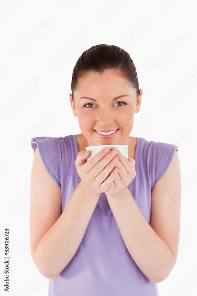 Attractive woman enjoying a cup of coffee while standing Attractive woman enjoying a cup of coffee while standing