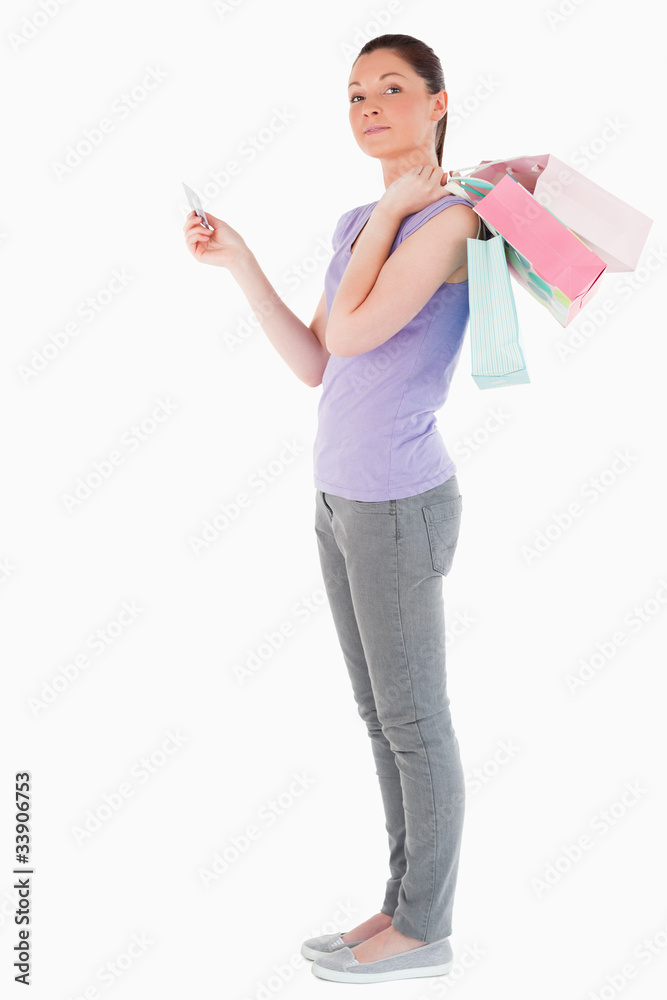 Good looking woman with a credit card holding shopping bags whil Good looking woman with a credit card holding shopping bags whil