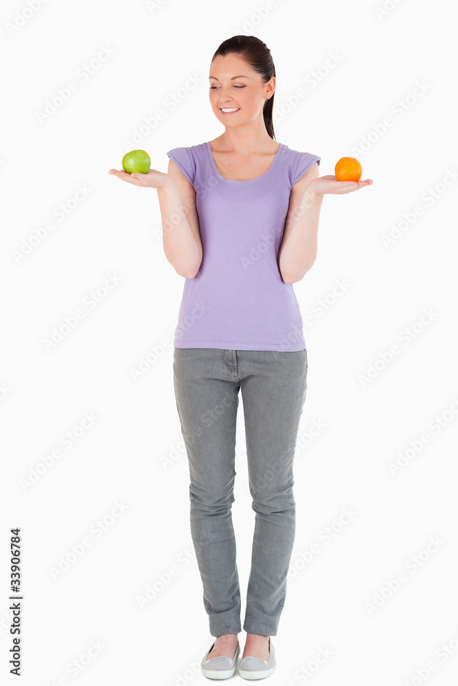 Attractive woman holding fruits while standing Attractive woman holding fruits while standing