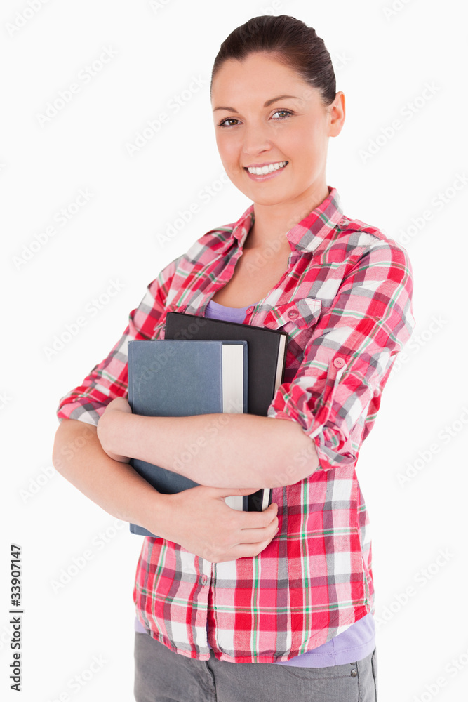 Beautiful female posing with books while standing Beautiful female posing with books while standing