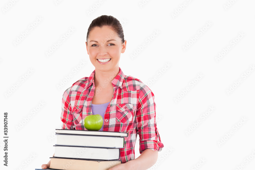 Beautiful female holding and a apple and books while posing Beautiful female holding and a apple and books while posing