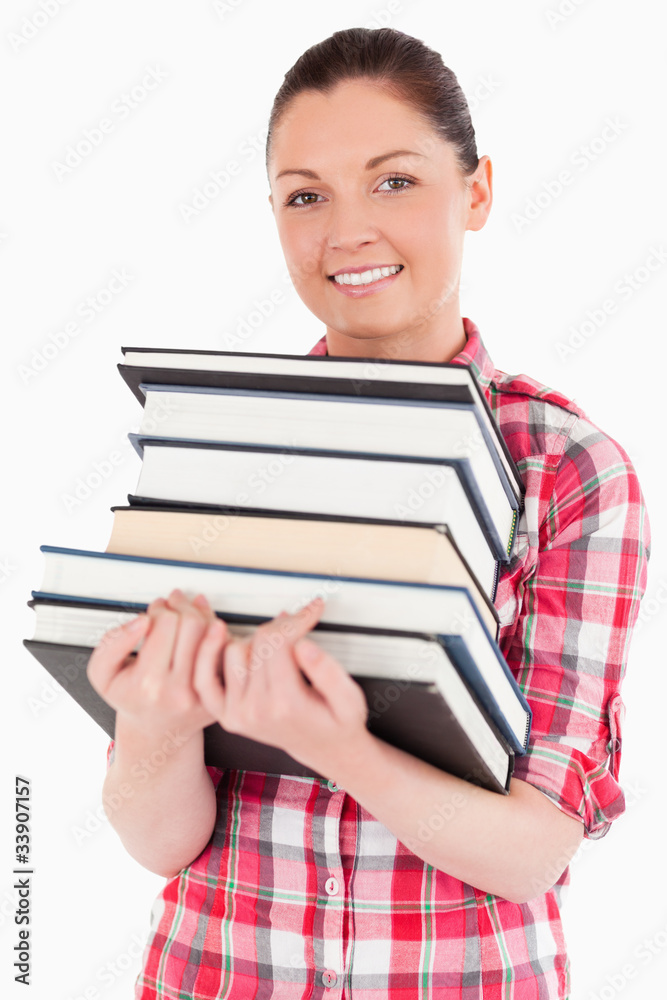 Charming female posing with books while standing Charming female posing with books while standing