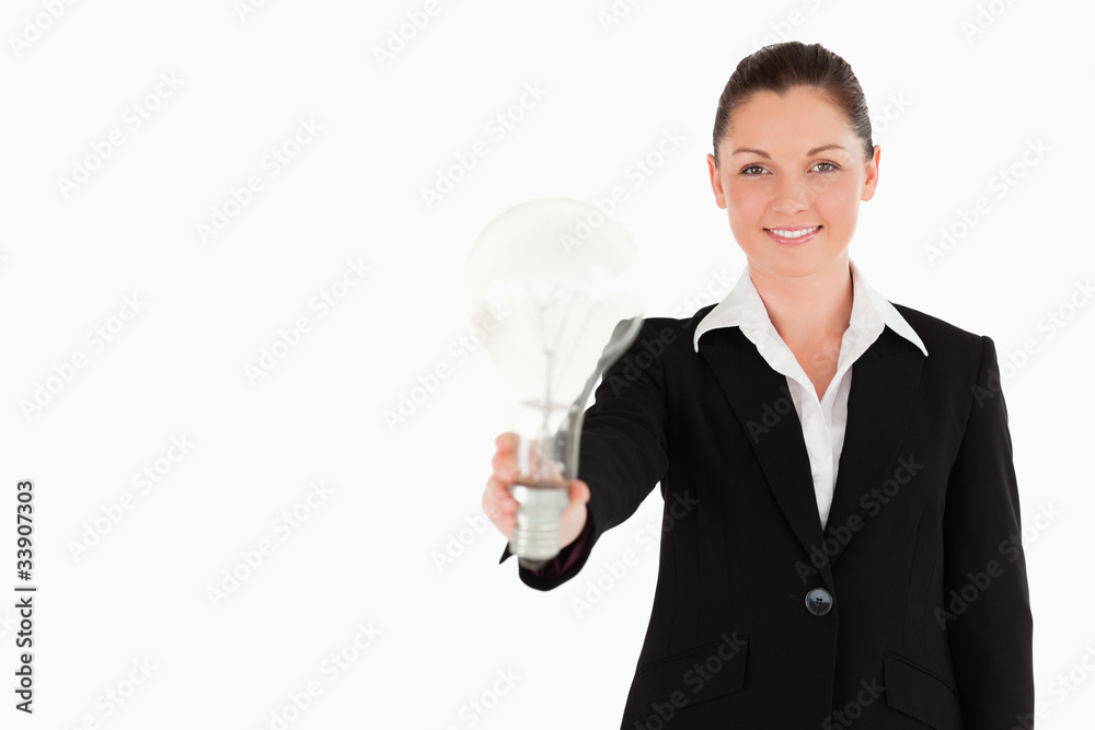 Attractive woman in suit holding a light bulb while standing Attractive woman in suit holding a light bulb while standing