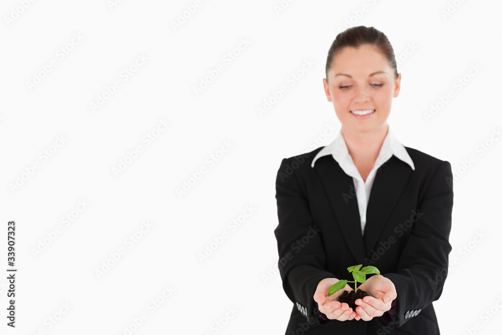 Pretty woman in suit holding a small plant Pretty woman in suit holding a small plant