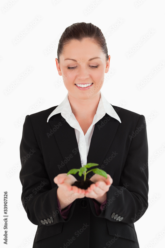 Attractive woman in suit holding a small plant Attractive woman in suit holding a small plant
