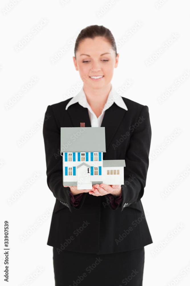 Attractive woman in suit holding a miniature house Attractive woman in suit holding a miniature house