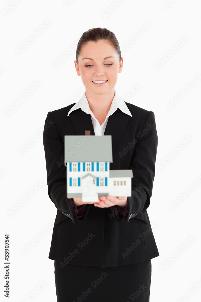 Beautiful woman in suit holding a miniature house Beautiful woman in suit holding a miniature house