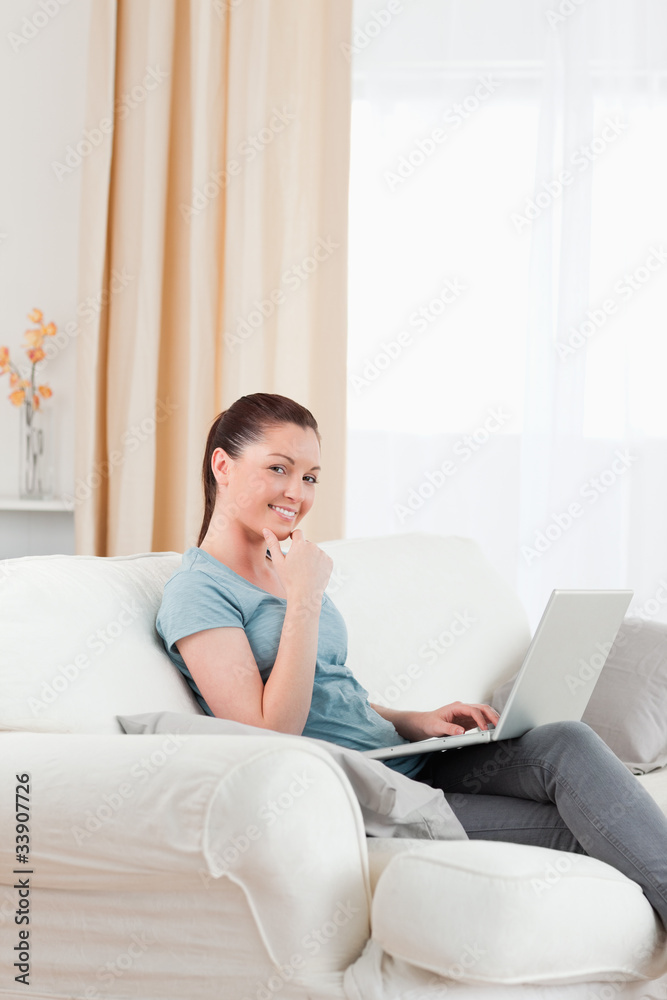 Gorgeous woman relaxing with her laptop while sitting on a sofa Gorgeous woman relaxing with her laptop while sitting on a sofa