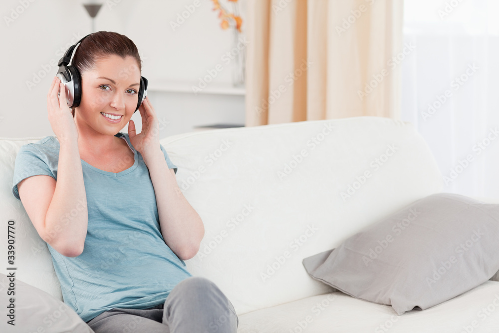 Attractive woman relaxing with headphones while sitting on a sof Attractive woman relaxing with headphones while sitting on a sof