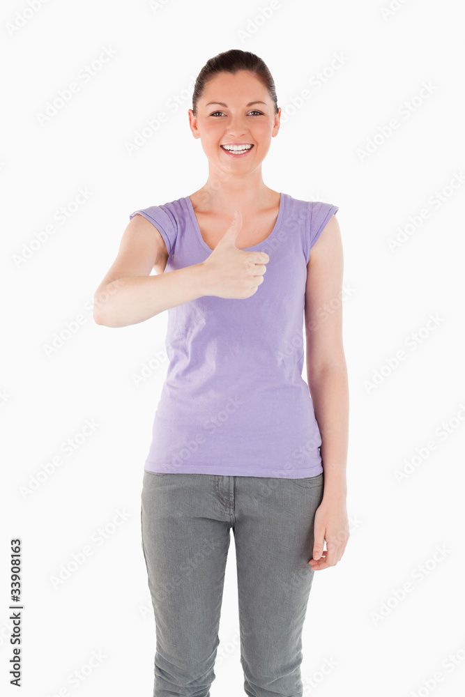 Beautiful woman posing with her thumb up while standing Beautiful woman posing with her thumb up while standing