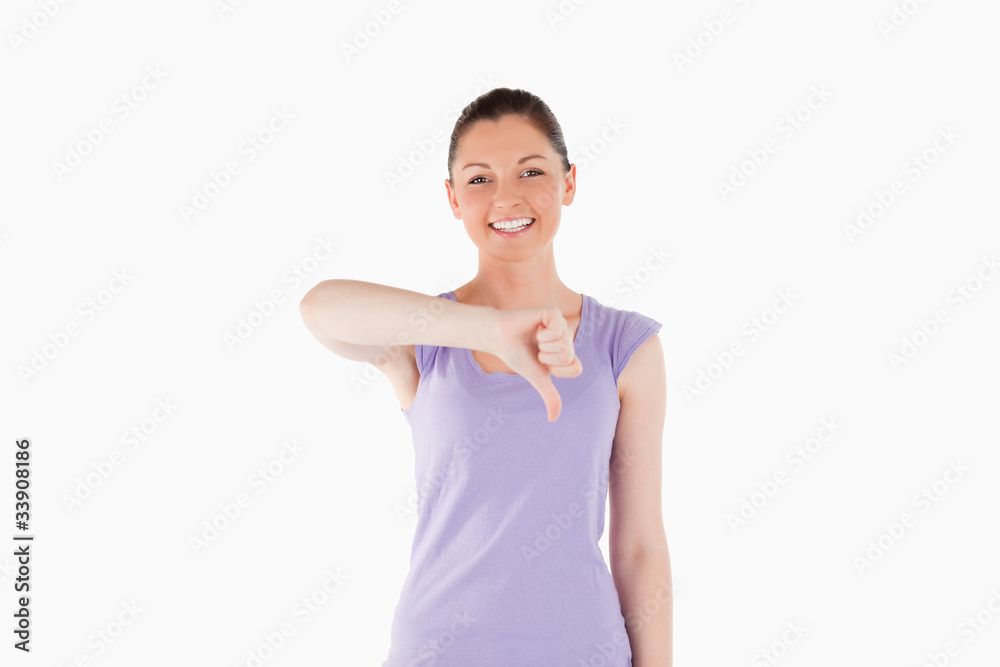 Attractive woman pointing her thumb down while standing Attractive woman pointing her thumb down while standing