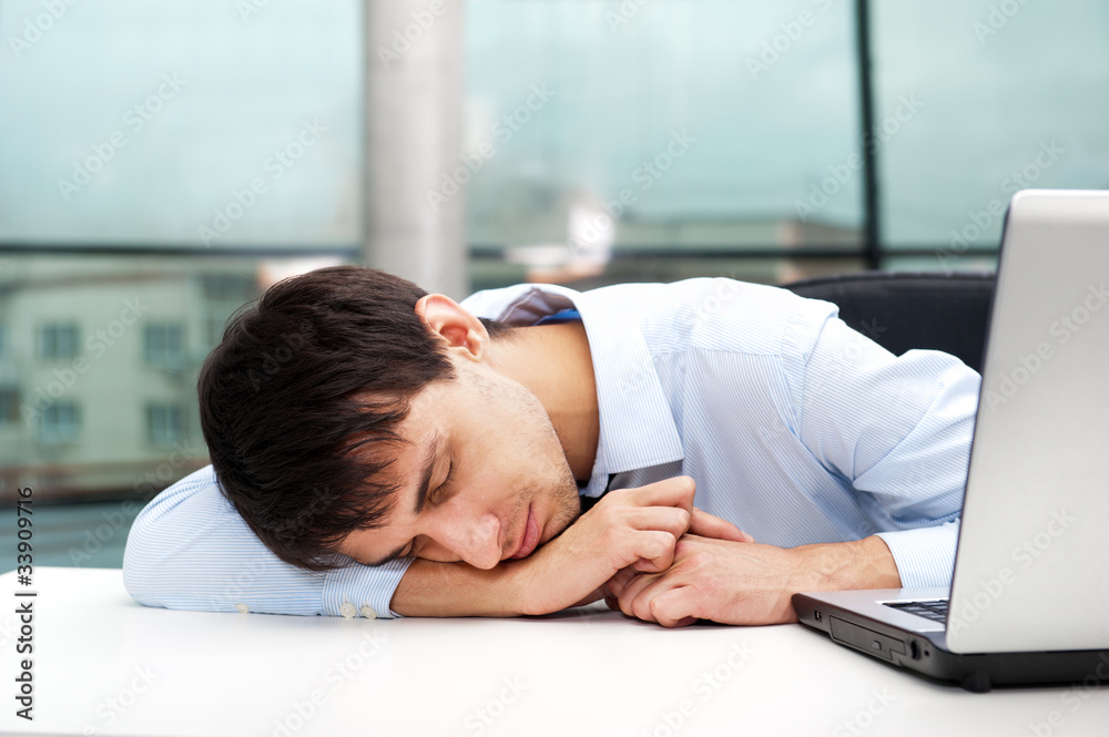 Portrait of a tired young business man sleeping on the table Portrait of a tired young business man sleeping on the table